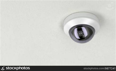 Dome security camera attached on white ceiling