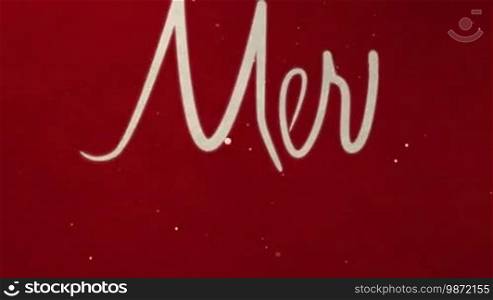 Drawing text MARRY CHRISTMAS on red paper with snow