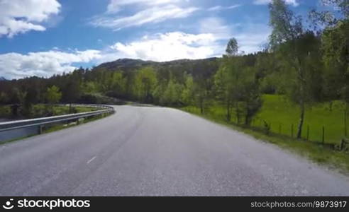 Driving a Car on a Mountain road in Norway with high snow wall