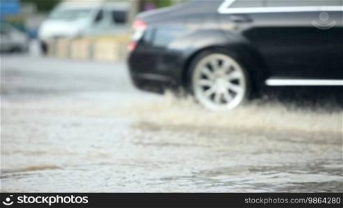 Driving cars in bad condition after rain on a city road