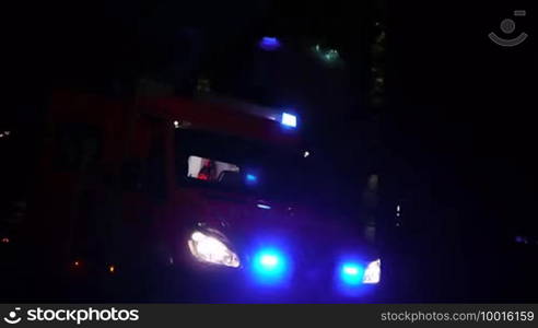 Ein Einsatzwagen, Krankenwagen bzw. eine Ambulanz mit aktivierter Alarmleuchte nachts, a German ambulance car with flashing beacon is shown, emergency