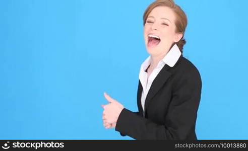 Excited smiling businesswoman giving the thumbs up gesture for approval, success, or hope, thumbs pointing to blank copyspace