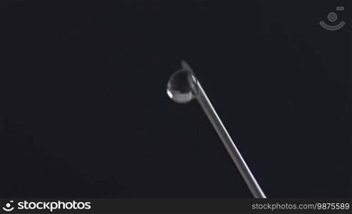 Extreme macro shot of syringe needle dripping