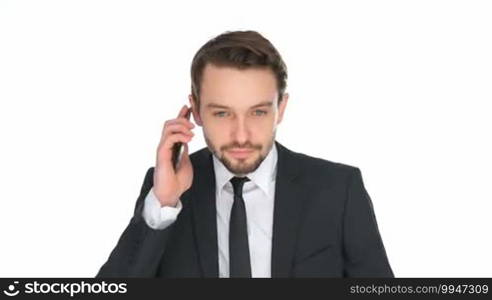 Exuberant businessman celebrating a victory or success punching the air with his fists and smiling happily while holding his mobile phone, isolated on white