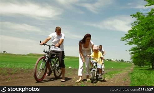 Family Cycling Outdoors In Summer