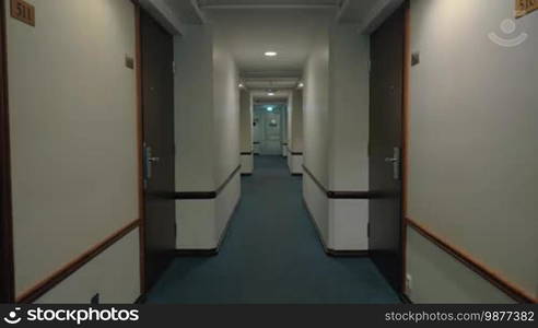 Family with child walking with luggage in hotel hallway and entering their room