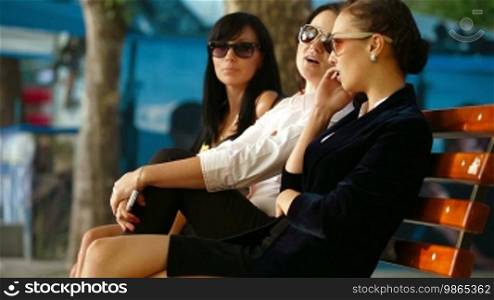 Female friends sitting on a bench in the park