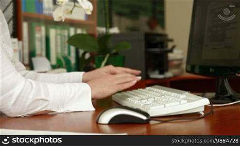 Female hand typing on a keyboard in the office