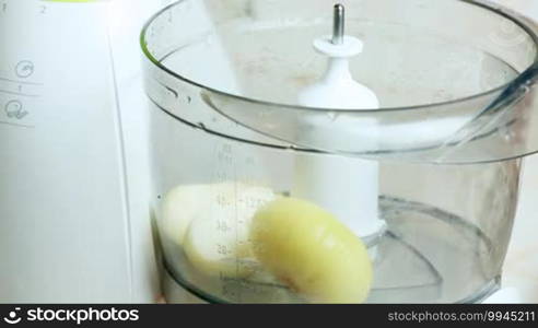 Female hand using kitchen unit cut pieces of onion timelapse closeup