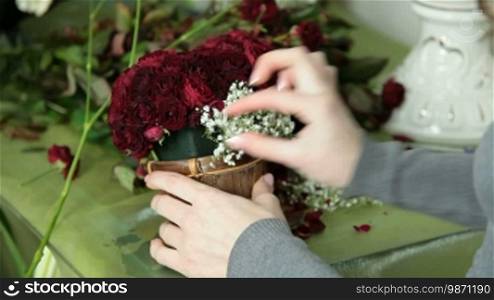 Female Hands Arranging Valentine's Day Rose Heart Bouquet In Flower Shop Closeup