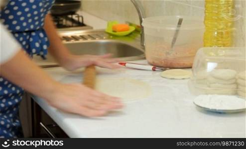 Female Hands Rolling Dough On Counter Top, Closeup