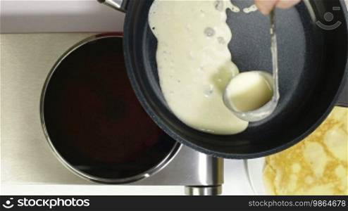 Female pouring pancake batter into the frying pan