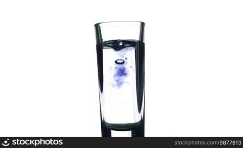 Filling a glass of colored liquid on a white background.