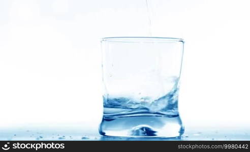 Filling glass with water on white background
