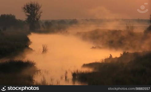 Fisherman fishes early in the morning. Sunrise on lake.