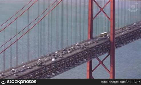 Fließender Verkehr auf der Brücke von Lissabon; rote Brücke aus Stahl über dem Fluss Tejo.