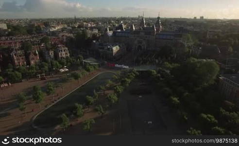 Flying over Rijksmuseum and Art Square with I amsterdam slogan and pond. Capital view at sunset