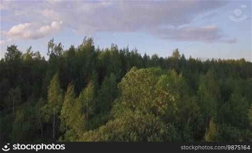 Flying over the woods, village and railway running through it. Scene at sunset, Russia