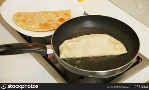 Food preparation - Chebureki (popular meal of Tatar and Caucasian cuisine) fried in oil