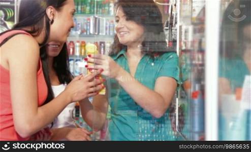 Friendly shop representative offers goods to a buyer in the cosmetics department