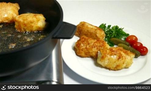 Frying chicken breast roll on a pan.