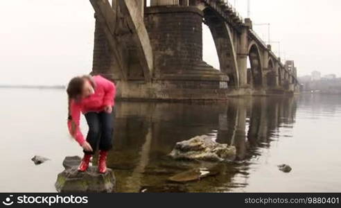 Girl throwing pebble in the water