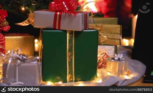 Girl using digital tablet computer near Christmas tree and gifts. Dolly shot