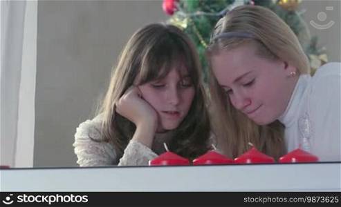 Girls using smart phone near Christmas tree at home