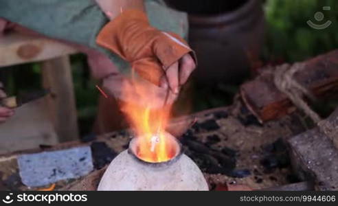 Glass artist in his workshop. Making glass beads in traditional way