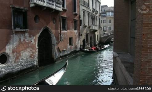 Gondola ride on a canal and old house facades in Venice.