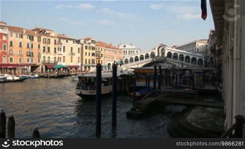 Gondolas and boats on the Grand Canal in Venice, in the background the Rialto Bridge.