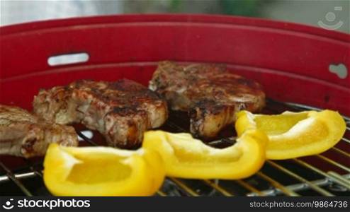 Grilling at summer weekend. Fresh steaks preparing on grill, Side View