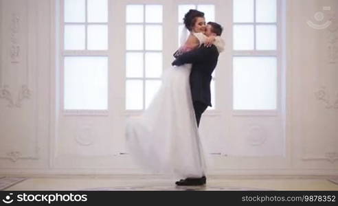 Groom meets bride, hug and whirl her on wedding day