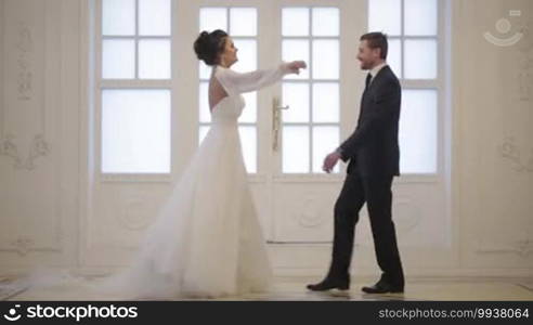 Groom meets bride, hug and whirl her on wedding day