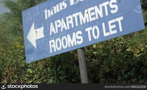 Grungy advertising banner showing the way to apartments and rooms to let with a view of a woman going in that direction