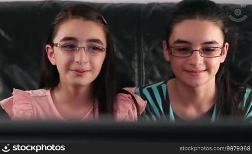 Happy girls with glasses watching TV