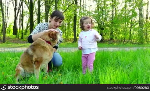 Happy people, family life, lifestyle, leisure, nature, animals, dogs, outdoors spring recreation. Portrait of mother and daughter smiling, woman and child, baby, girl with pet, dog. 7of8