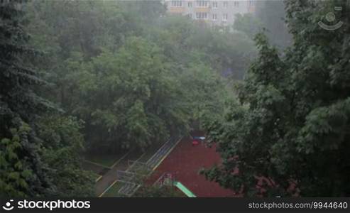 Heavy rain against the tree and a children's playground