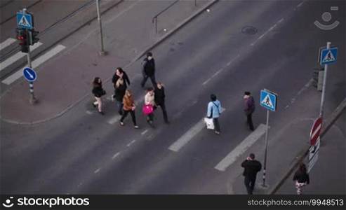 High angle shot of pedestrians crossing the road on zebra on green traffic light