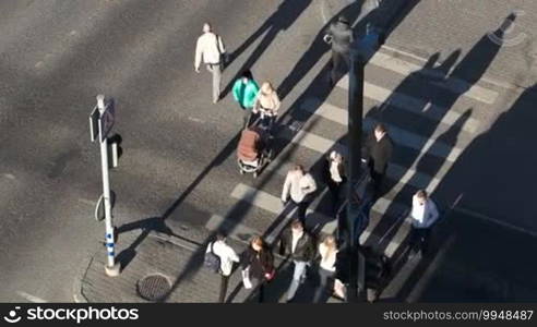 High angle shot of pedestrians crossing the street on zebra on green light