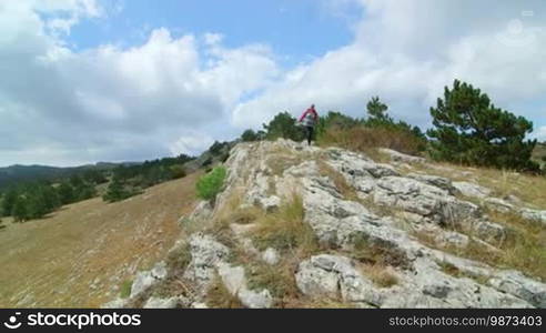 JIB CRANE: Woman day hiking highlands walking along bare stone plateau Ai-Petri