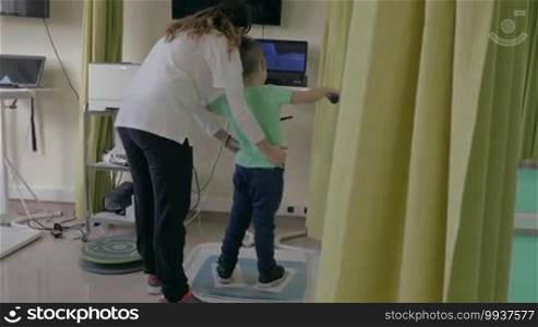 KALIKRATIA, GREECE - JANUARY 12, 2016: At the medical clinic Evexia, a robotic system analyzes and trains the balance of a little boy's walk. Each year, nearly 19 million tourists visit Greece, with over 15% coming for medical tourism.