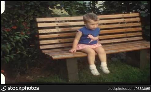 Kleinkind sitzt auf einer Bank