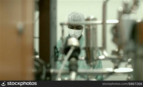 Lab technician working as a researcher in a biotechnology plant with machinery
