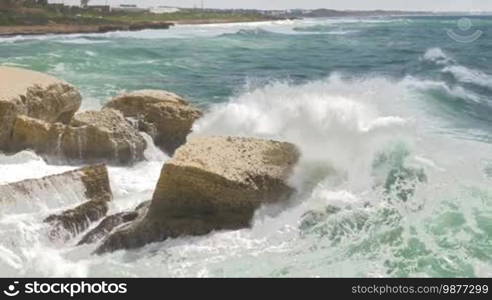 Landscape with Rosh Hanikra coast and strong waves of turquoise sea crashing white chalk rocks