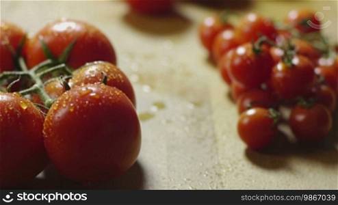Large group of red tomatoes on domestic kitchen table. Dolly shot