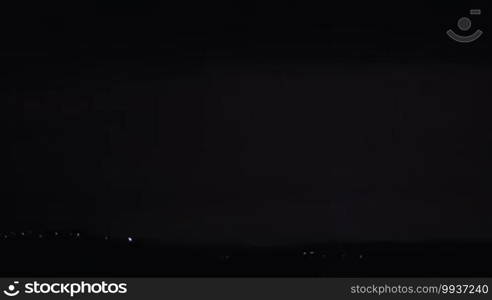 Lightning discharge in the dark sky during night thunderstorm