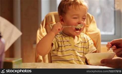 Little boy eats porridge.
