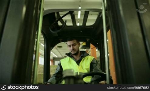 Logistics business and shipping facility with manual worker operating forklift to move boxes and parcels, man at work in warehouse, worker in industry. 8 of 19