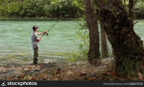 Lonely man and leisure activities, mid adult fisherman on holidays on river, having fun and catching fish. Dolly shot. Part 6 of 8
